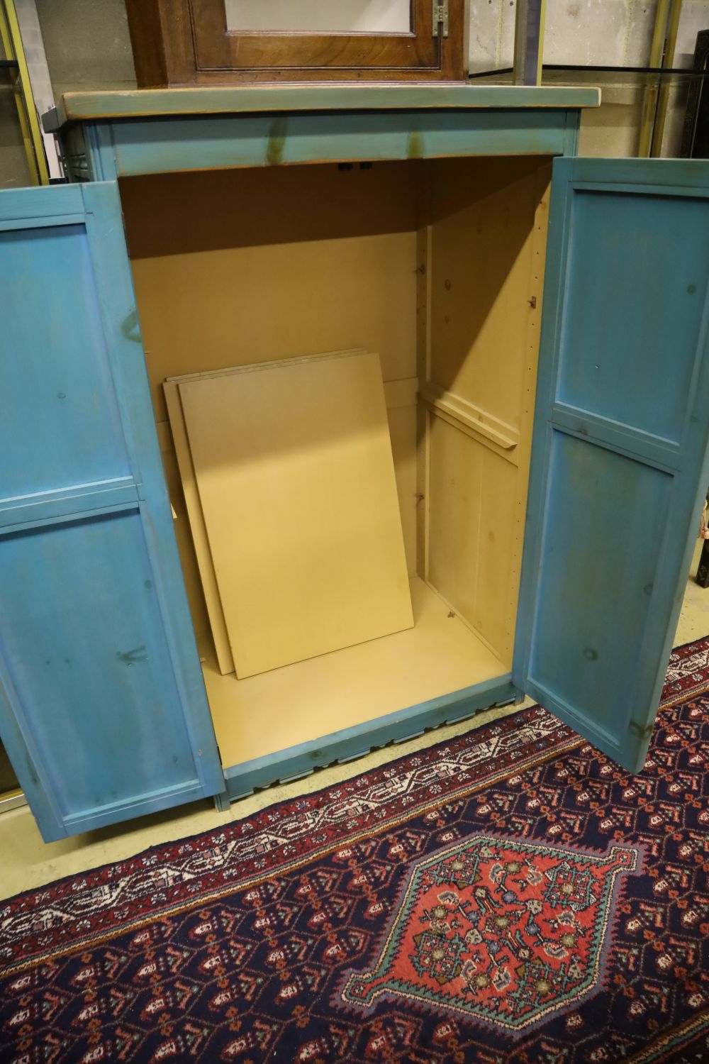 A distressed carved and blue-painted pine double wardrobe, width 96cm